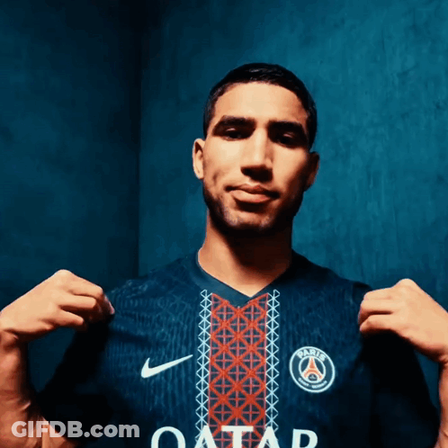 A Man Is Wearing A Blue Shirt With The Word Qatar On It GIF