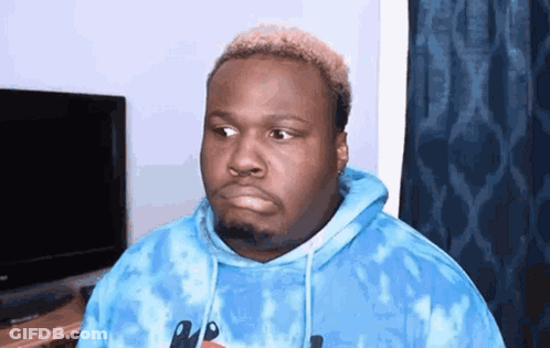 A Man Is Wearing A Blue Tie Dye Hoodie And Making A Funny Face . GIF