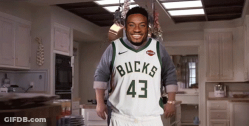 A Man Is Wearing A Bucks Jersey And Shorts GIF