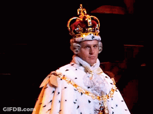 A Man Is Wearing A Crown And A White Robe . GIF