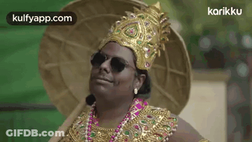 A Man Is Wearing A Crown , Sunglasses , A Necklace , And A Hat . GIF