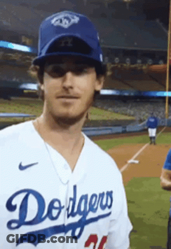 A Man Is Wearing A Dodgers Jersey And Hat GIF