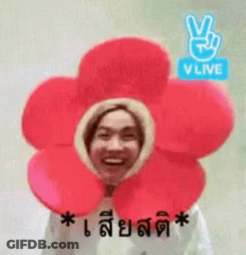 A Man Is Wearing A Flower Hat With A Peace Sign On It . GIF