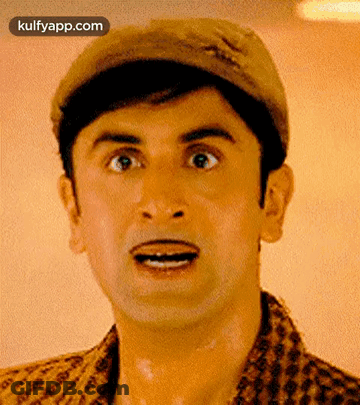 A Man Is Wearing A Hat And Making A Funny Face . GIF