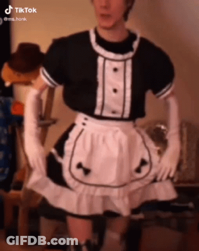 A Man Is Wearing A Maid Costume With Gloves And A Skirt . GIF