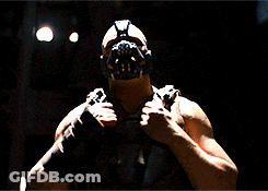 A Man Is Wearing A Mask And Holding A Gun GIF