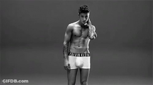 A Man Is Wearing A Pair Of Calvin Klein Underwear With A Black Band Around His Waist . GIF