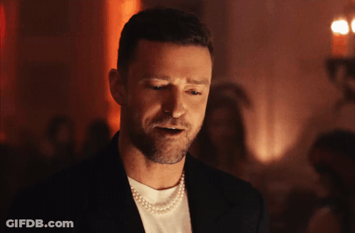 A Man Is Wearing A Pearl Necklace And A Black Jacket GIF