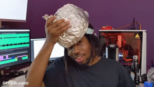 A Man Is Wearing A Potato Wrapped In Tin Foil On His Head GIF