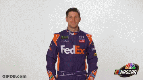 A Man Is Wearing A Purple And Orange Fedex Racing Suit GIF