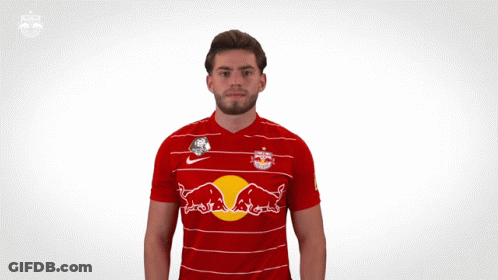 A Man Is Wearing A Red And White Striped Shirt With A Red Bull On It GIF