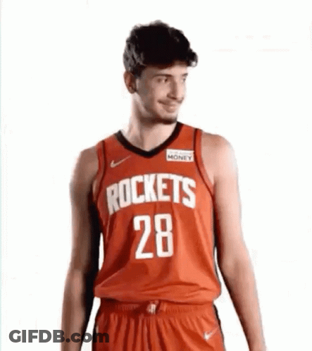 A Man Is Wearing A Red Rockets Jersey And Shorts . GIF