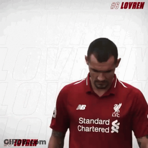 A Man Is Wearing A Red Shirt That Says Standard Chartered GIF