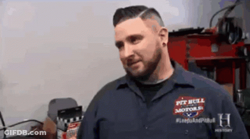 A Man Is Wearing A Shirt That Says Pit Bull Motors GIF