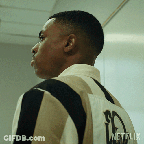 A Man Is Wearing A Striped Shirt With A Netflix Logo On The Back GIF