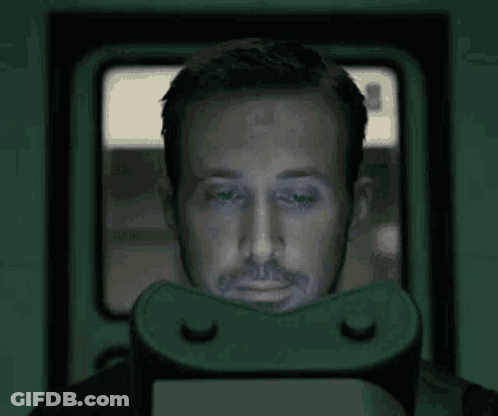 A Man Is Wearing A Virtual Reality Headset And Looking At A Screen . GIF