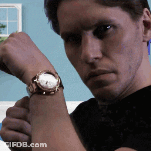 A Man Is Wearing A Watch On His Wrist And Looking At The Camera GIF