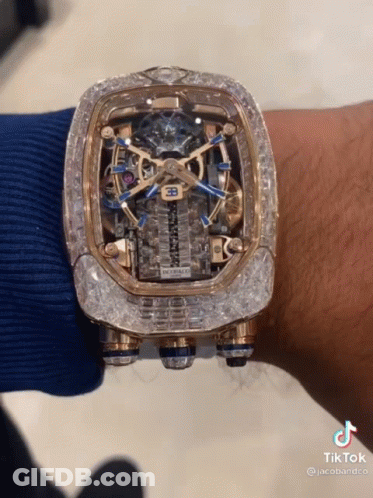 A Man Is Wearing A Watch That Has A Bugatti Logo On It GIF