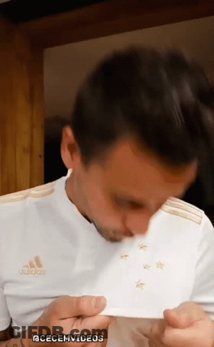 A Man Is Wearing A White Adidas Shirt With Gold Stars On It GIF