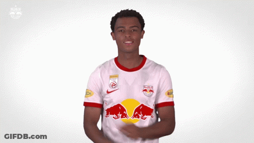A Man Is Wearing A White Jersey With Red Bulls On The Front GIF