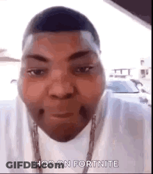 A Man Is Wearing A White Shirt And A Chain Around His Neck . GIF