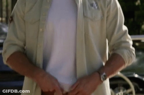 A Man Is Wearing A White Shirt And A Watch While Standing In Front Of A Car . GIF