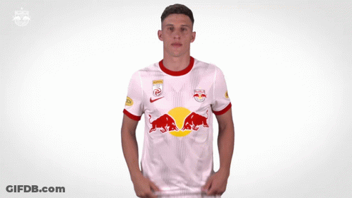 A Man Is Wearing A White Shirt With A Red Bull On It GIF