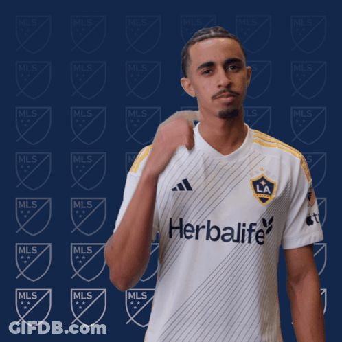 A Man Is Wearing A White Shirt With The Word Herbalife On It GIF