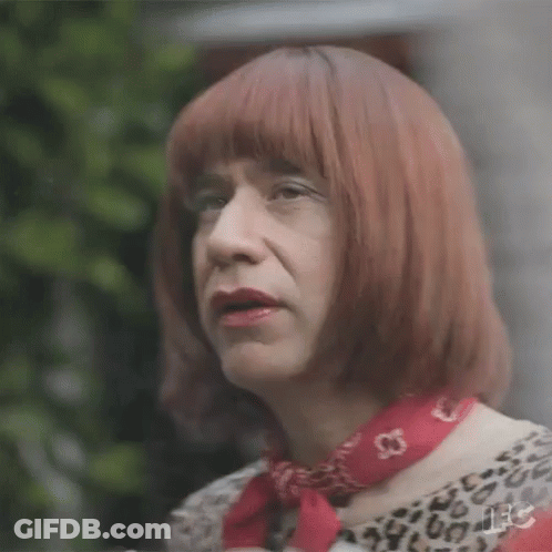 A Man Is Wearing A Wig And A Red Scarf . GIF