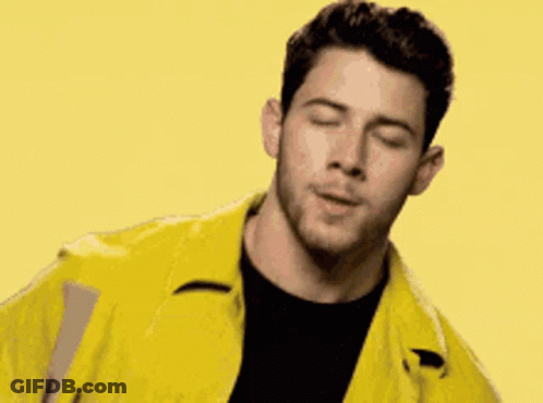 A Man Is Wearing A Yellow Jacket And A Black Shirt . GIF