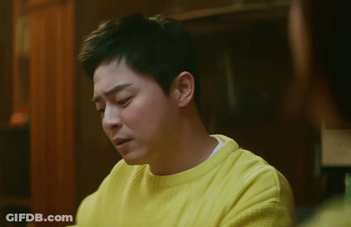 A Man Is Wearing A Yellow Sweater And Making A Funny Face GIF