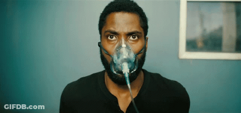 A Man Is Wearing An Oxygen Mask On His Face GIF