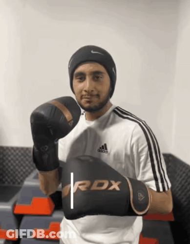 A Man Is Wearing Boxing Gloves That Say Rdx On Them GIF