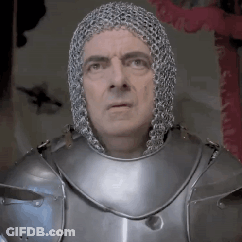 A Man Is Wearing Chain Mail And Armor And Looking At The Camera GIF