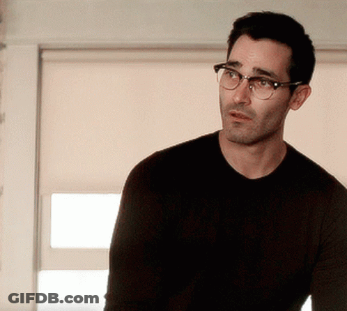 A Man Is Wearing Glasses And A Black Shirt GIF