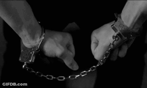 A Man Is Wearing Handcuffs With A Pentagram On Them GIF