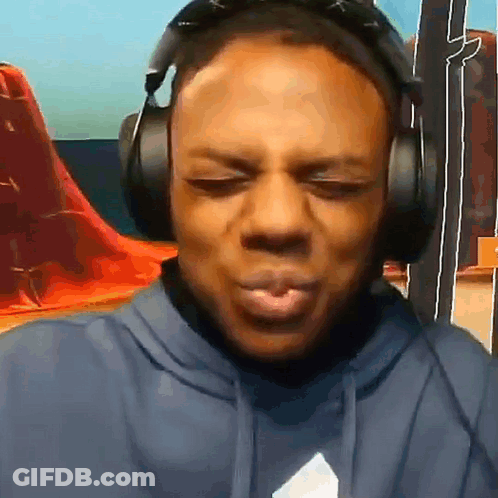 A Man Is Wearing Headphones And Making A Funny Face . GIF