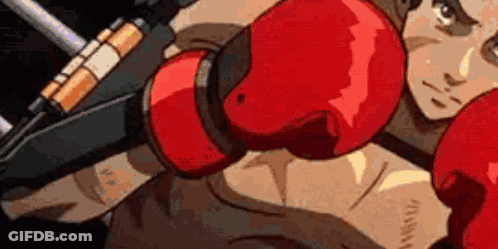 A Man Is Wearing Red Boxing Gloves And Holding A Gun In His Hand . GIF