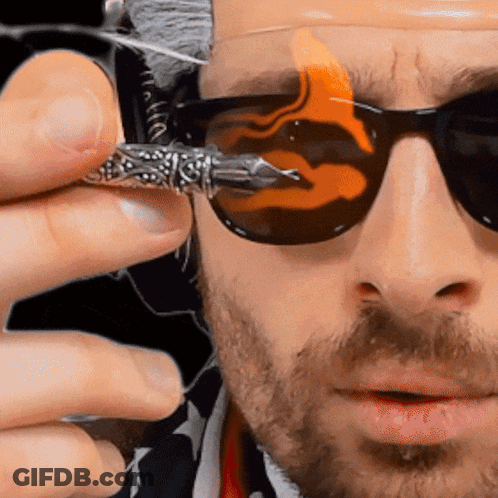 A Man Is Wearing Sunglasses And Holding A Pen GIF