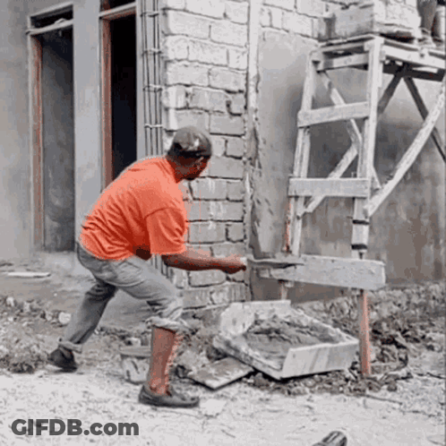 A Man Is Working On A Brick Wall With A Shovel GIF