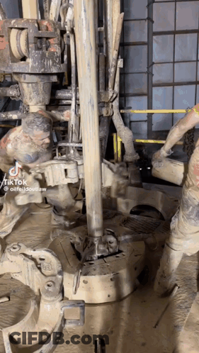 A Man Is Working On A Machine That Says Tik Tok On It GIF