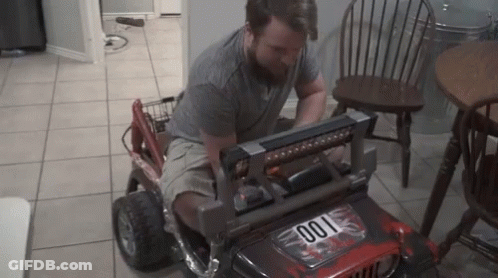 A Man Is Working On A Toy Jeep That Has The Number 001 On The Front GIF