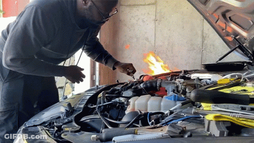 A Man Is Working On The Engine Of A Car GIF