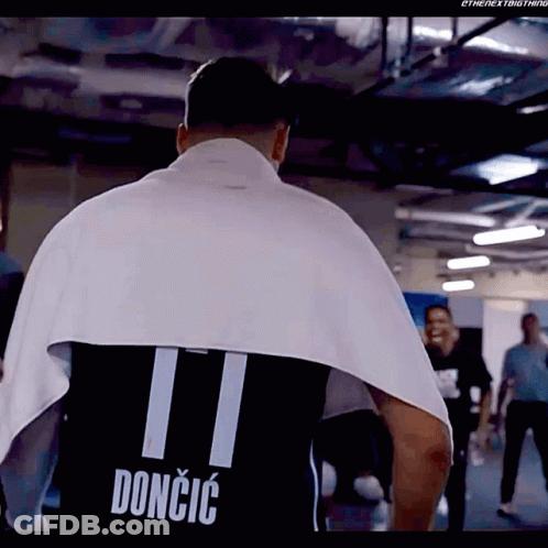 A Man Is Wrapped In A Towel And Has The Name Doncic On His Shirt GIF