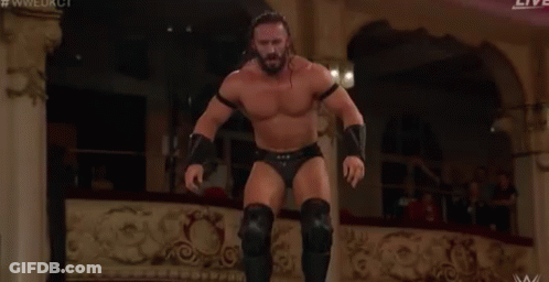 A Man Is Wrestling Another Man In A Ring . GIF