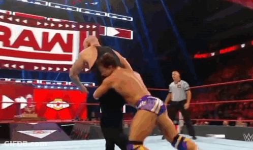 A Man Is Wrestling Another Man In A Wrestling Ring . GIF