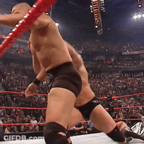 A Man Is Wrestling Another Man In A Wrestling Ring . GIF