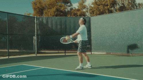 A Man Jumps In The Air While Playing Tennis GIF