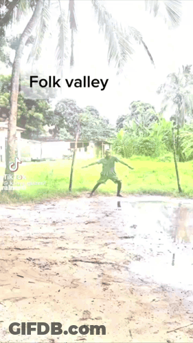 A Man Kicking A Soccer Ball In A Muddy Field With The Words Folk Valley Above Him GIF