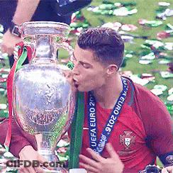 A Man Kisses A Trophy That Says Euro 2016 On It GIF